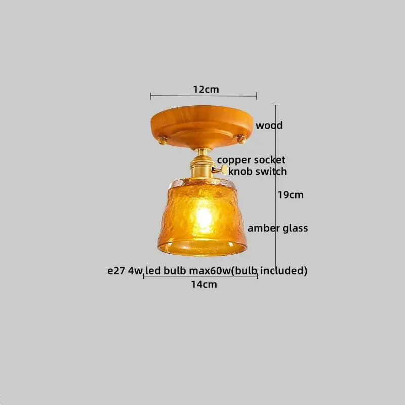 A modern amber glass and brass led ceiling lamp with wooden mount and copper socket for dining room lighting