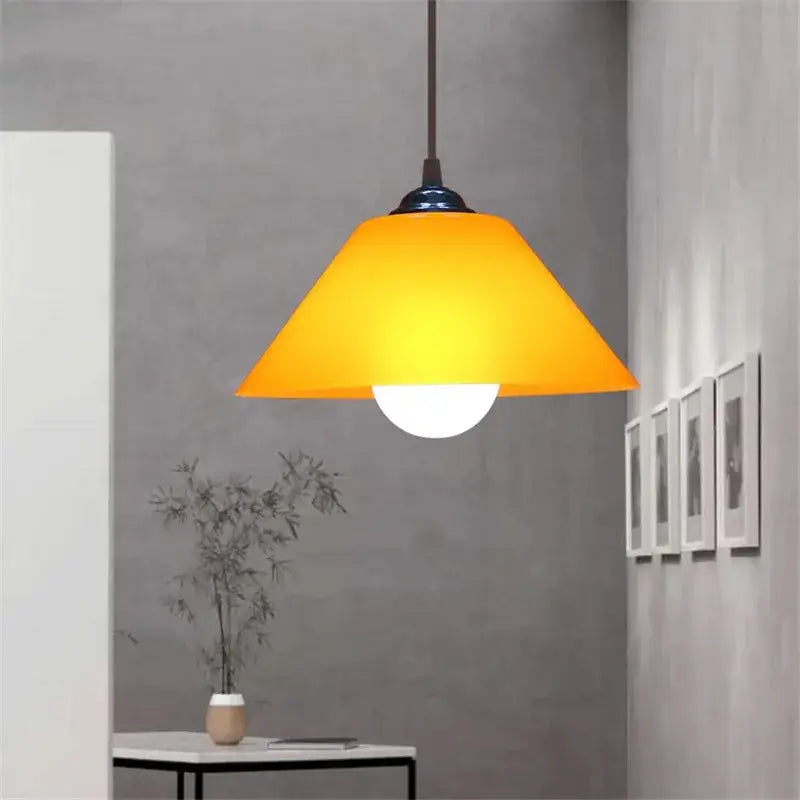 Modern amber glass pendant light with sleek black iron finish fixture ideal for dining room illumination