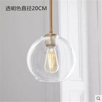 Modern amber glass ball led pendant light with clear glass globe, brass rod, and exposed filament bulb for kitchen decorbites decor