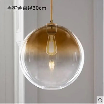 Modern amber glass ball led pendant light with gradient gold-to-clear finish and brass hardware for kitchen decorbites decor