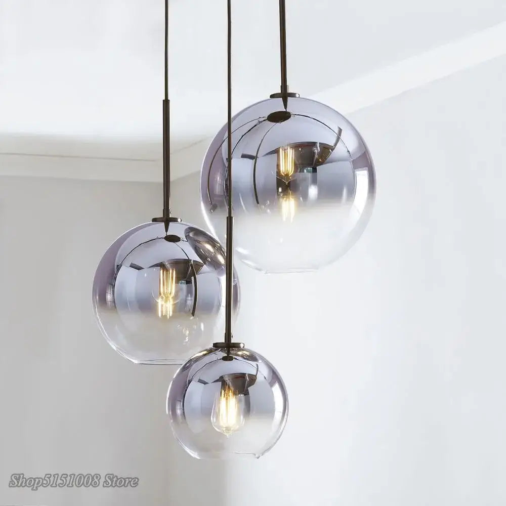 Modern amber glass ball led pendant light with metallic finish and exposed filament bulbs for kitchen decorbites decor