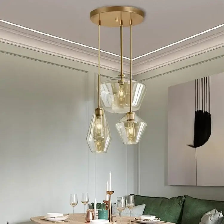 Brass-finished pendant light with three amber geometric glass shades for dining room or living room chandelier