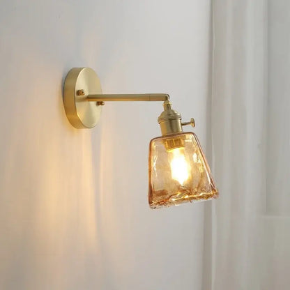 A warm-toned modern amber glass copper led wall lamp with textured shade perfect as a bedroom sconce