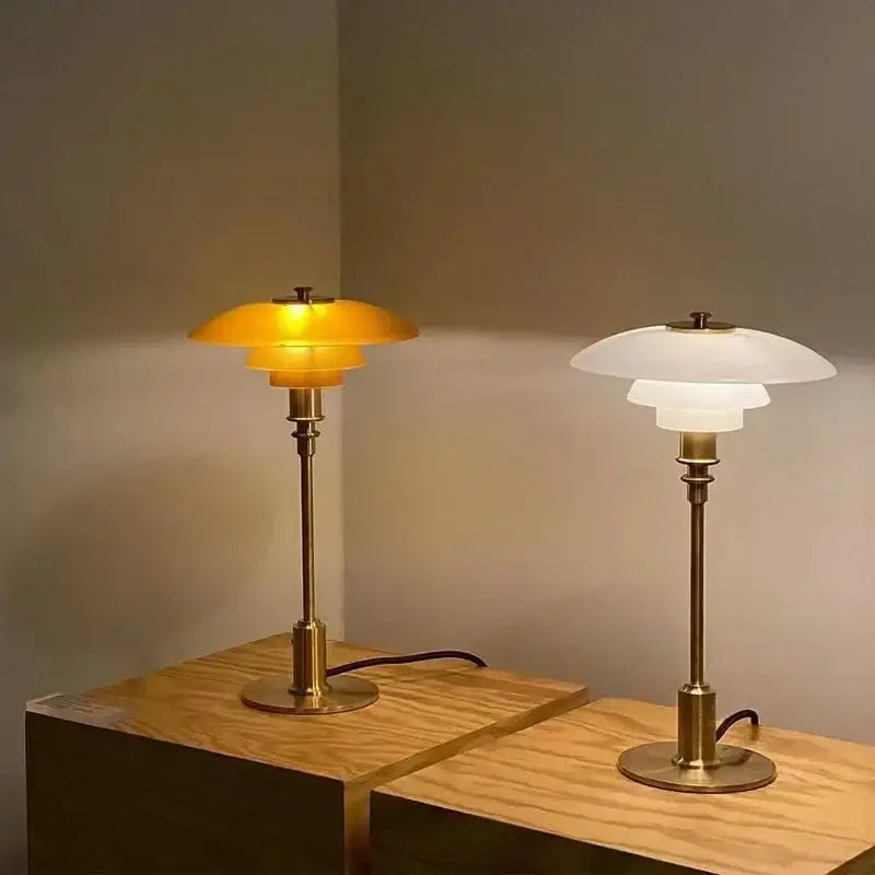 Two vintage-style decorbites glass desk lamps with golden brass finish and amber and frosted glass shades for living room decor