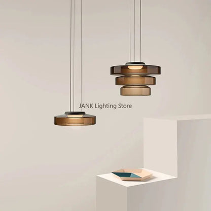 Modern amber glass led pendant lights feature tiered stacked discs and sleek black metal frames for dining room chandelier