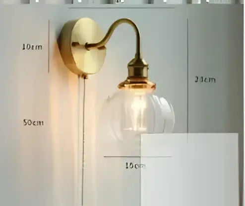 Brass-finished modern amber glass led wall lamp with clear bulb and elegant curved arm for bedroom lighting