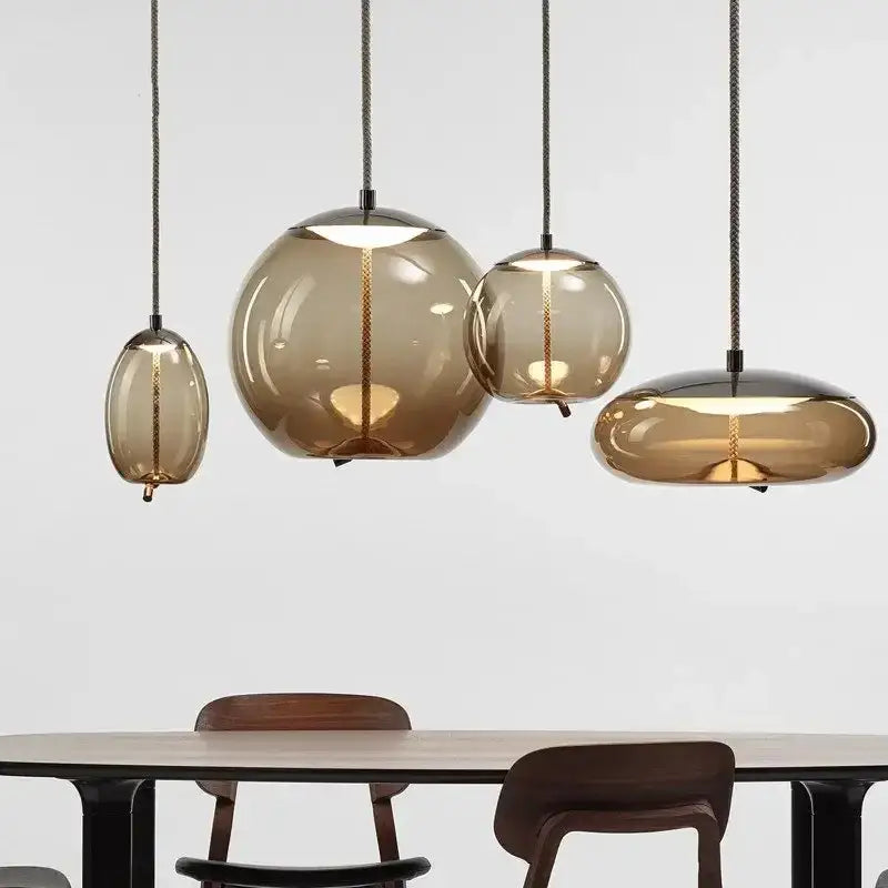 Set of modern amber glass pendant lights with gold accents and black cords perfect for bedroom decorbites brokis knot
