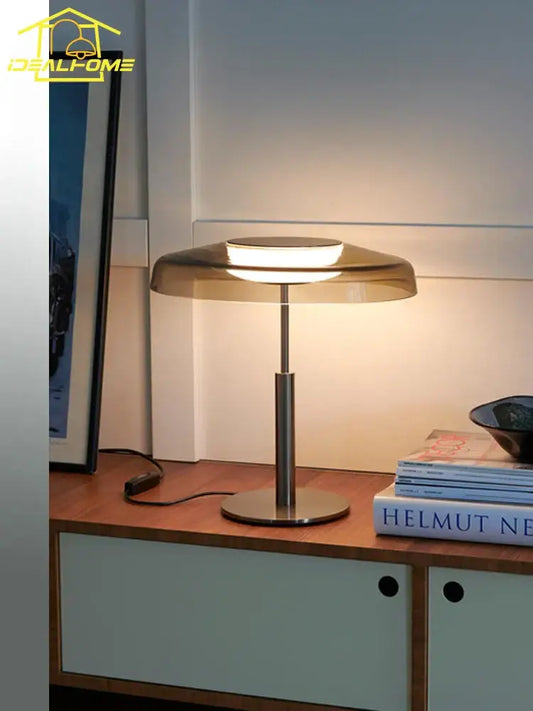 Modern brushed metal table lamp with translucent amber glass shade and circular base for decorbites dora glass table use