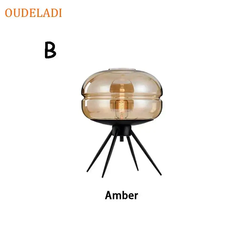 Modern amber glass table lamp with black tripod base designed as a decorbites glass table lamp for bedroom decor