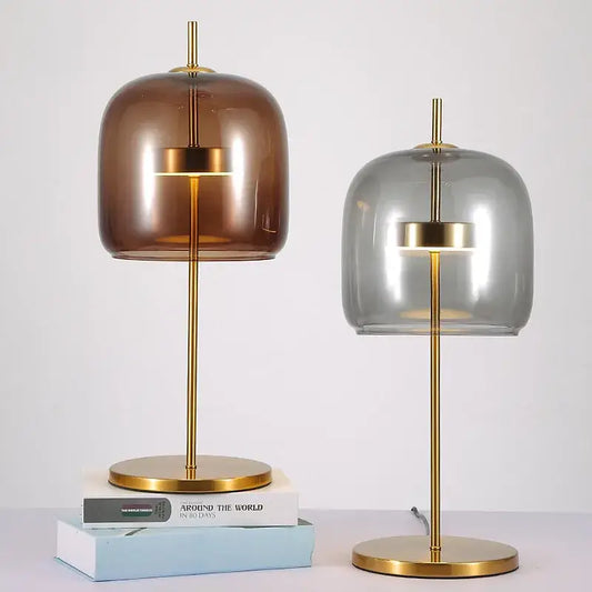 Two modern decorbites glass table lamps with gold metal bases and amber and gray translucent shades with led light