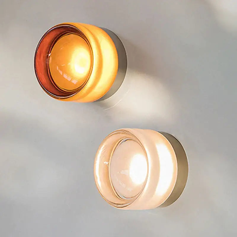 Two modern decorbites amber jelly led wall sconces with frosted glass shades emit warm amber and soft cream light