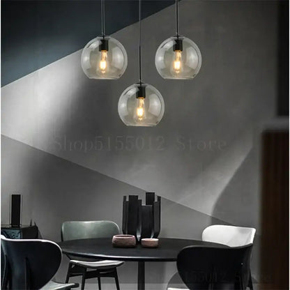Three clear glass ball led pendant lights with exposed filament bulbs hang from black cords for dining room decorbites glass ball lighting