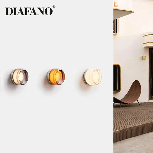 Three modern wall lamps by diafano with amber and white glass sconce led shades and metallic rims for living room