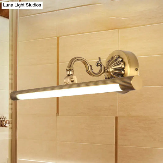 Modern antique brass integrated led wall light with brass finish ribbed cylindrical lamp and ornate scrollwork arm for vanity