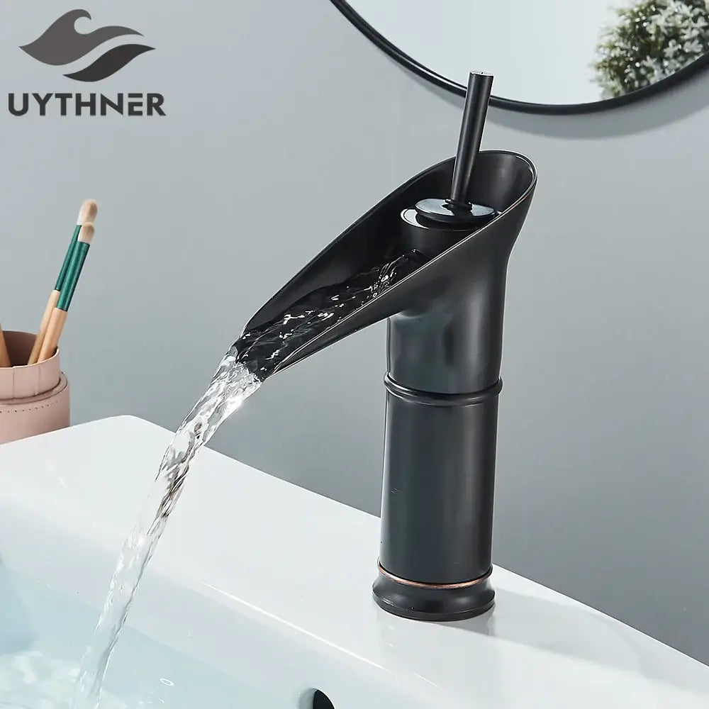 Modern antique brass and matte black waterfall faucet for bathroom sink with sleek design and subtle antique brass finish accents