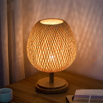 Warm-toned bamboo weave table lamp with circular base ideal for modern bedroom lighting and decor