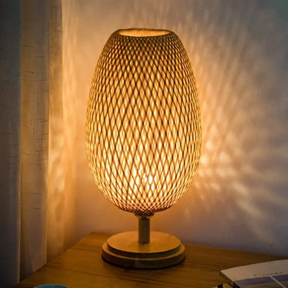 Warm-toned bamboo weave table lamp with an egg-shaped woven shade and wooden base for modern bedroom use