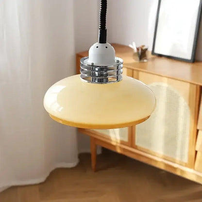 A sleek pale yellow glass led chandelier pendant light with chrome metal collar and black cord for dining room use