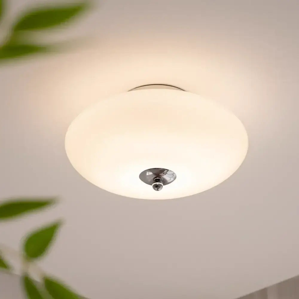 Modern bauhaus cream white ceiling lamp with a frosted cream white glass shade and polished brass light accents for bedroom