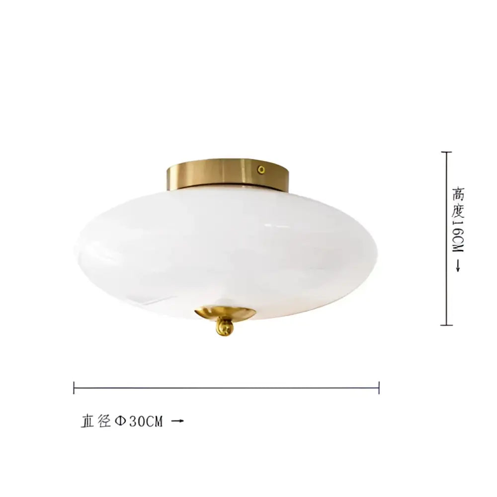 A modern bauhaus cream white ceiling lamp with cream white glass and a brass-finished metal base for bedrooms