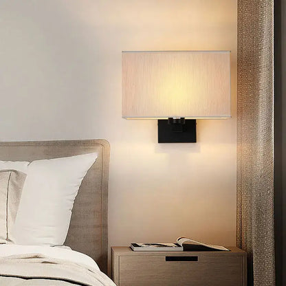 Modern beige and black elegant bedroom wall lamp with rectangular wall lamp featuring a textured fabric shade and metal base