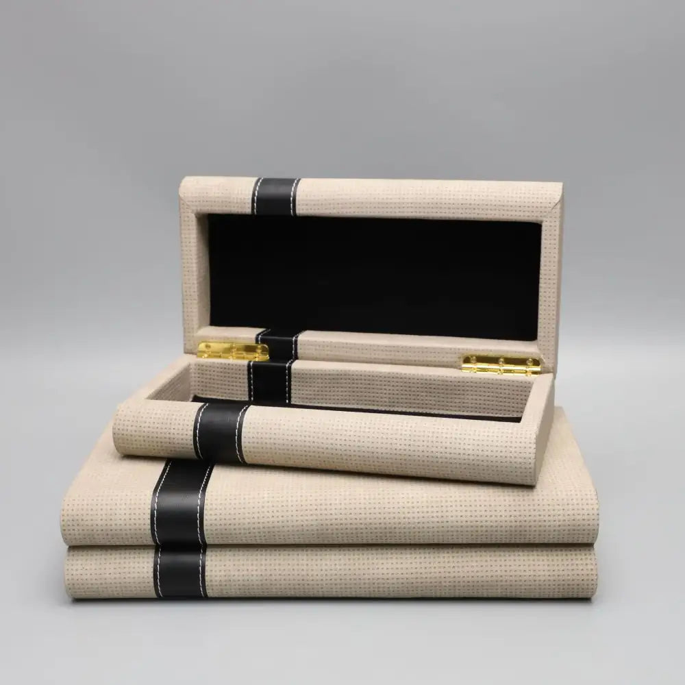 Modern beige geometric jewelry storage box with black leather straps and gold-tone hinges for bedroom organizer decorbites
