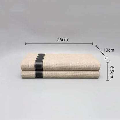 Beige linen napkins with a black leather strap complementing decorbites geometric jewelry storage box and bedroom organizer
