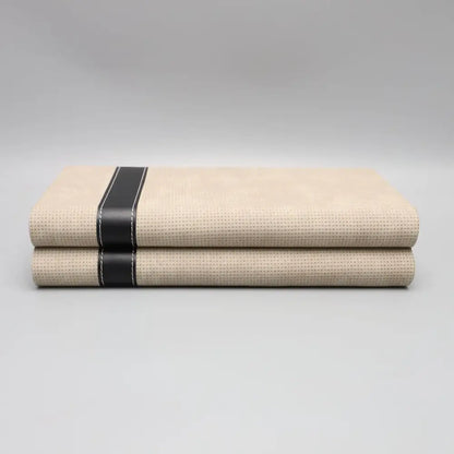 Modern beige geometric jewelry storage box with textured fabric and black leather straps for jewelry storage