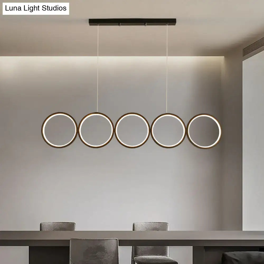 Modern minimalist DecorBites™ black hanging island pendant light with five circular metal rings and warm LED glow