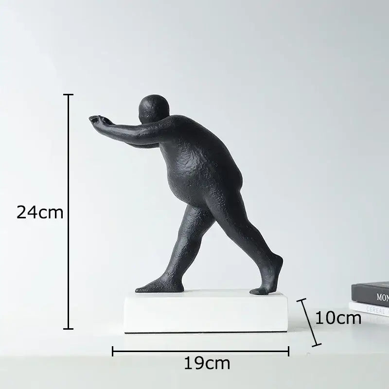 Modern black abstract resin sculpture of a stylized overweight person in mid-stride for home decor on white base