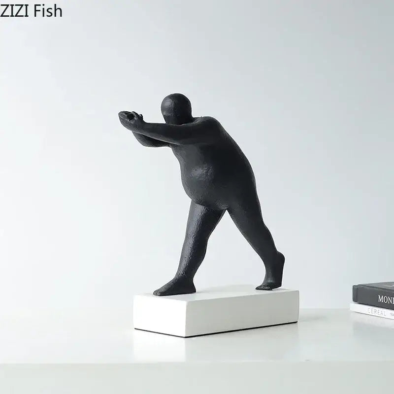Modern black abstract resin sculpture of a stylized overweight figure in an athletic pose for home decor