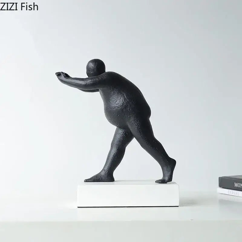 Modern black abstract resin sculpture of a stylized overweight figure in mid-stride on a white base for home decor