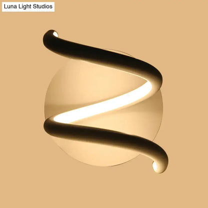 Modern black acrylic spiral sconce light fixture with sleek design and warm glowing light for bedroom lighting