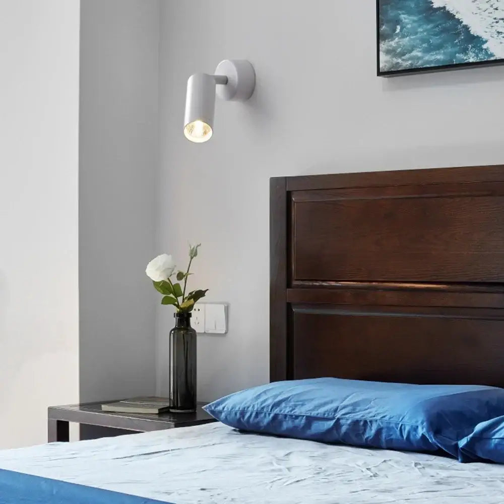 White cylindrical wall lamp with decorbites adjustable metal spotlight head and warm bulb for bedroom decor