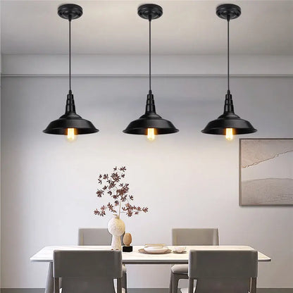 Three black aluminium modern pendant lights with exposed bulbs hang above a dining table for decorbites black aluminium decor