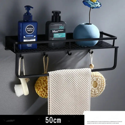 Modern black aluminum bathroom shelf with towel bar and mesh grid holding towel sponge loofah and soap dispenser