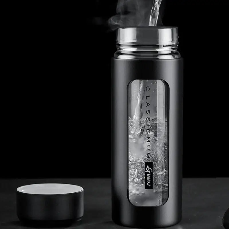 Modern black and amber insulated glass water bottle with matte finish silver lid and transparent window showing glass water inside