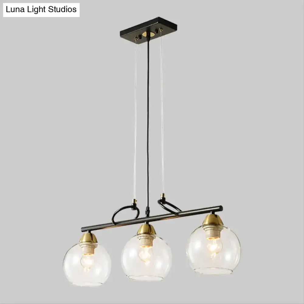Decorbites contemporary 3-bulb pendant light with black metal, smoke gray glass globes, and brass accents for hall island