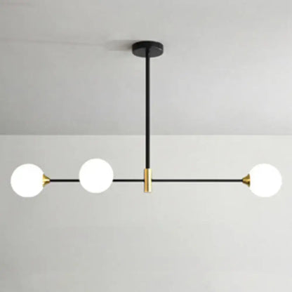Modern black metal island pendant with brass accents and frosted glass globe bulbs featuring adjustable chain cord length