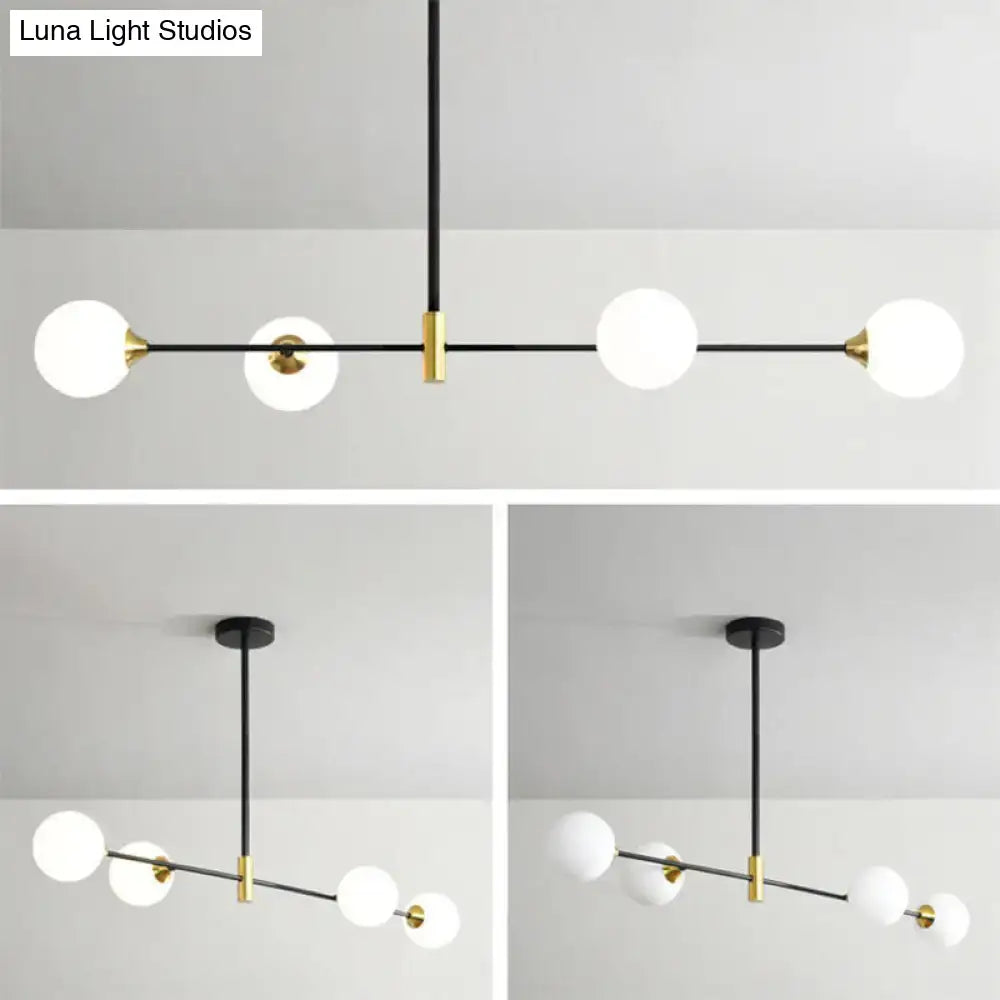 Modern black and brass metal island pendant with frosted glass globe bulbs and adjustable chain cord length for dining room