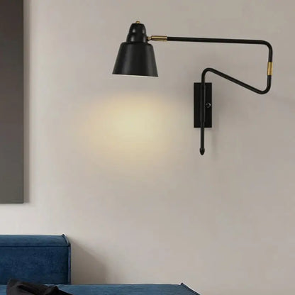 Black wall-mounted lamp with retractable arm and brass accents offers modern lighting for bedroom reading