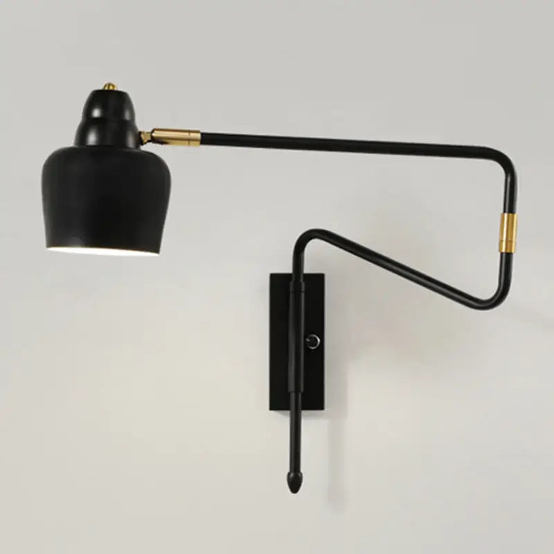 Modern black and brass wall-mounted reading lamp with retractable arm and curved articulated design for bedroom use