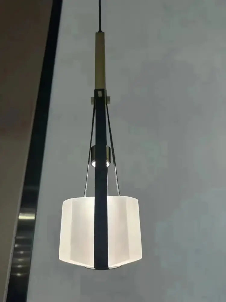 Modern pendant light with clear white resin hexagonal shade and black metal accents for kitchen use
