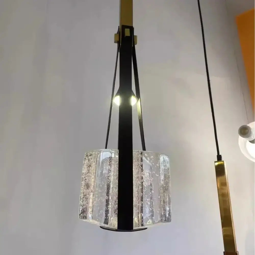 Modern pendant light with clear white resin textured glass shade and black leather straps for kitchen lighting