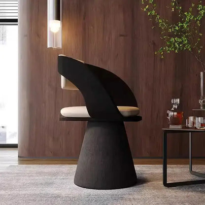 Black sculptural elegant rotating chair with cream cushion and tapered textured base for bedroom makeup stool