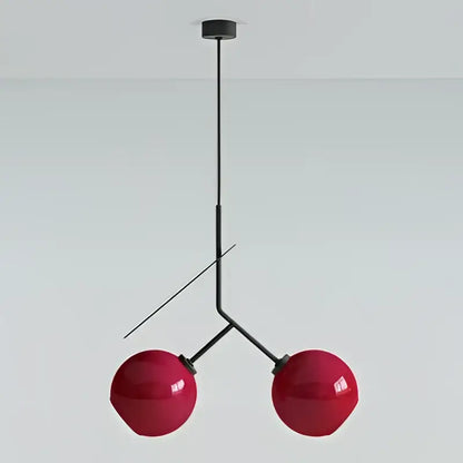 Modern black and crimson glass cherry pendant light featuring red spherical glass cherry pendant with black metal frame