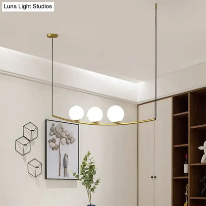 Modern metal chandelier with three frosted glass globes in black gold brass frame designed as light bubble island light