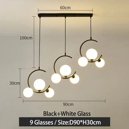 Modern black and gold glass ball pendant light with nine glowing white spheres in an asymmetrical design decorbites pendant light