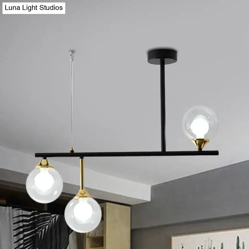 Modern black and gold pendant light fixture with three clear glass globe bulbs for dining room lighting
