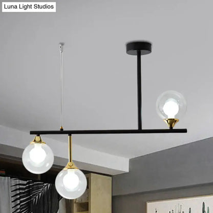 Modern black and gold pendant light fixture with three clear glass globe bulbs for dining room lighting